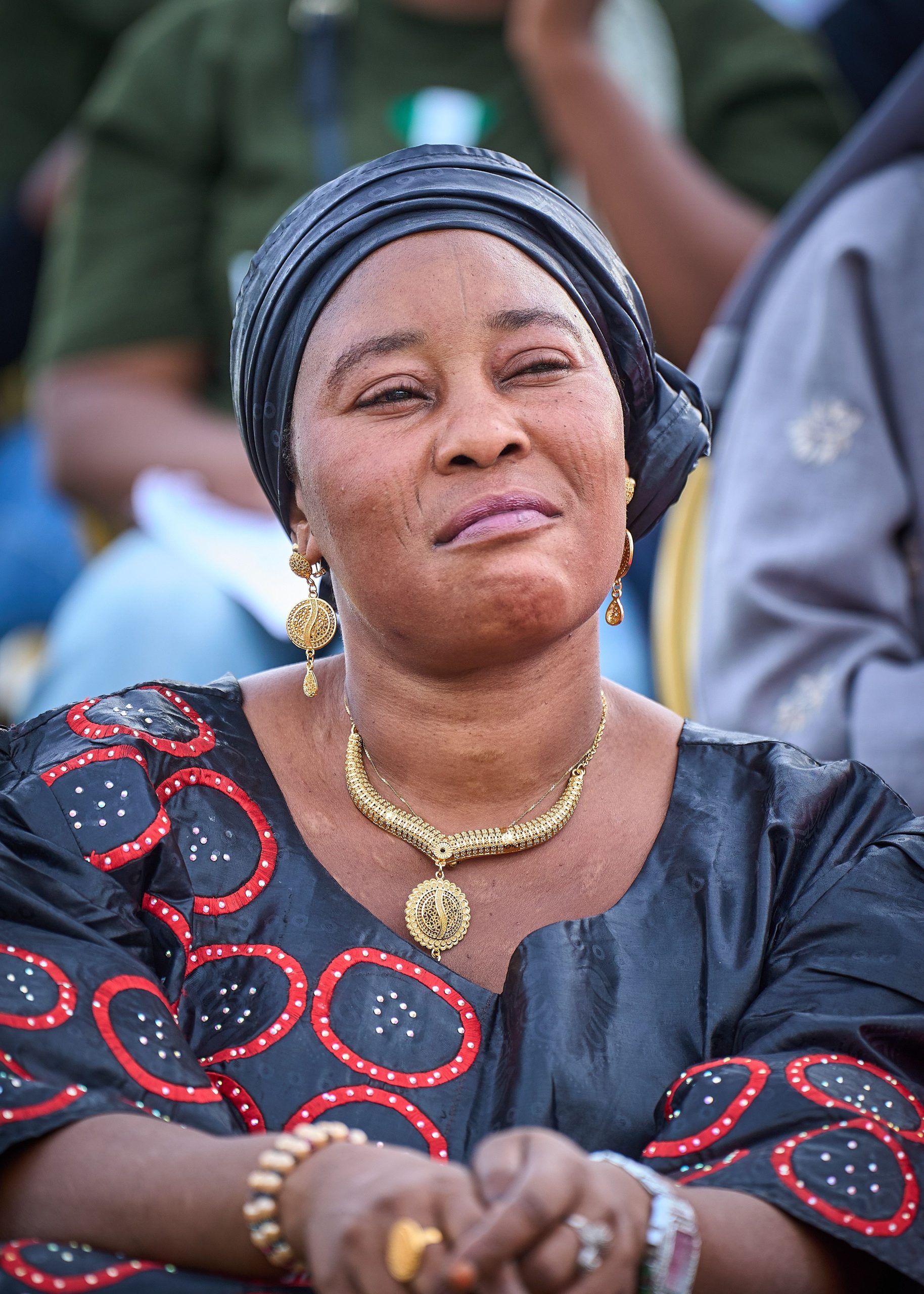 A woman in traditional African dress attends an outdoor event.